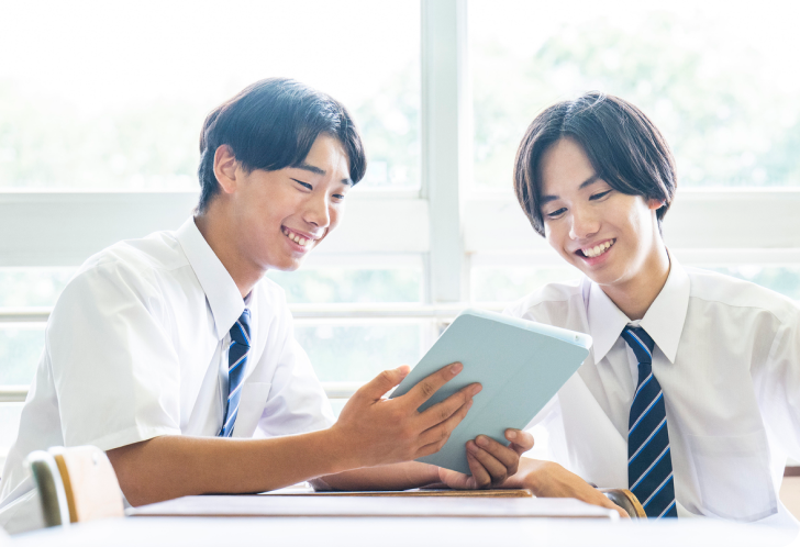 タブレットを見ながら話し合う生徒たち