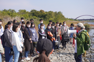 多摩川河川敷で河川への下水処理の状況について高田先生から説明